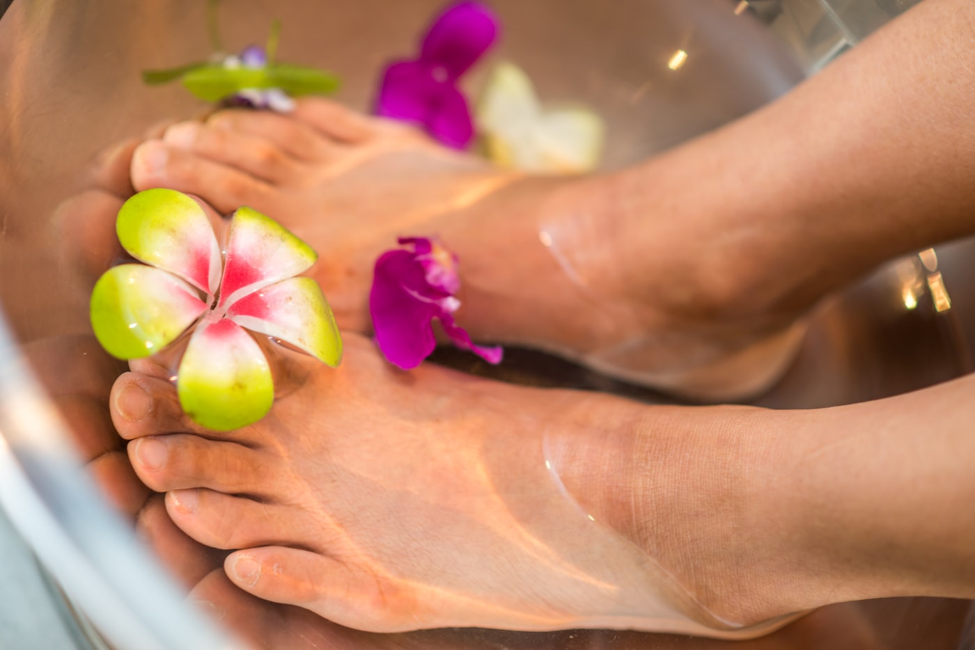 Piedi immersi in acqua con petali di fiori, momento di relax